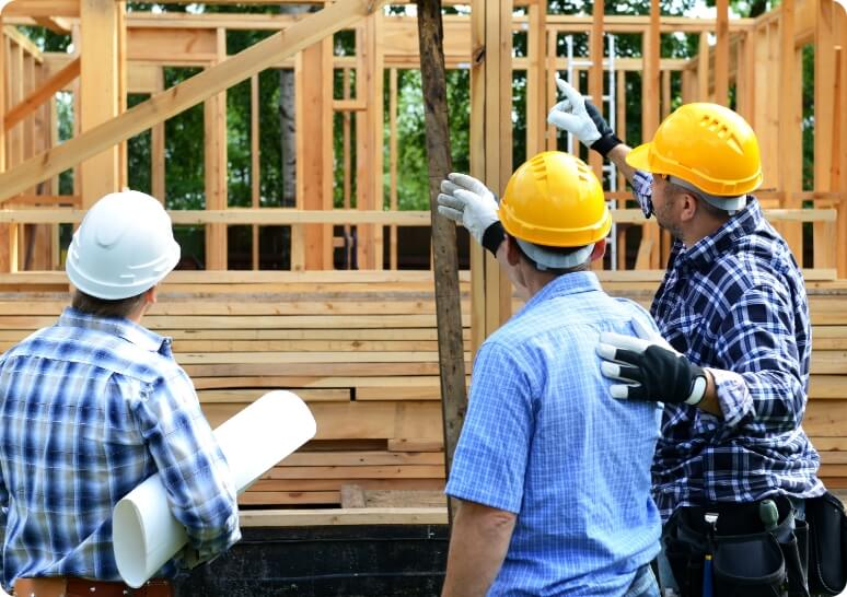 Group of contractors on a construction site pointing at a wooden frame